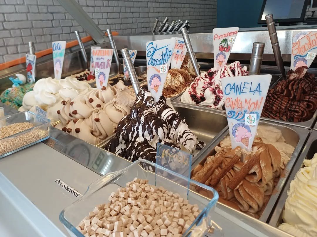 Vitrine de gelados com etiquetas de sabores e tabuleiros de coberturas