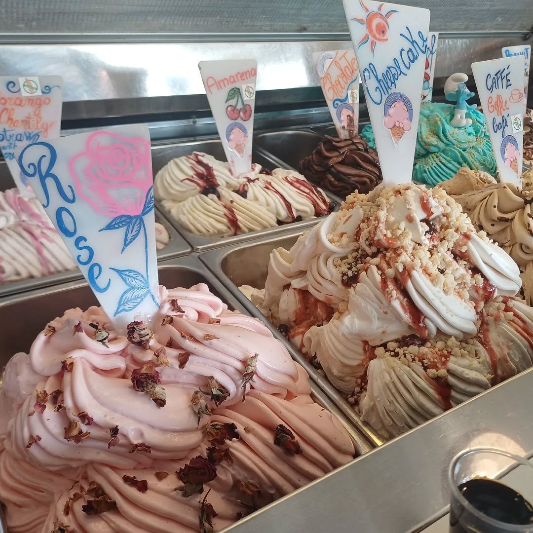 Vitrine com gelados cor-de-rosa e etiquetas de sabores escritas à mão